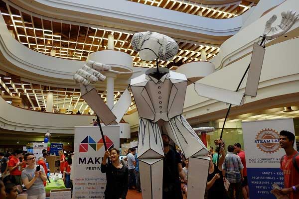 A large mantis puppet prays (typo deliberate) the crowd at the 2015 Maker Festival held at Toronto Reference Library.