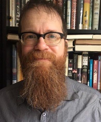 Photo of librarian Jeff Dodge in front of book shlef