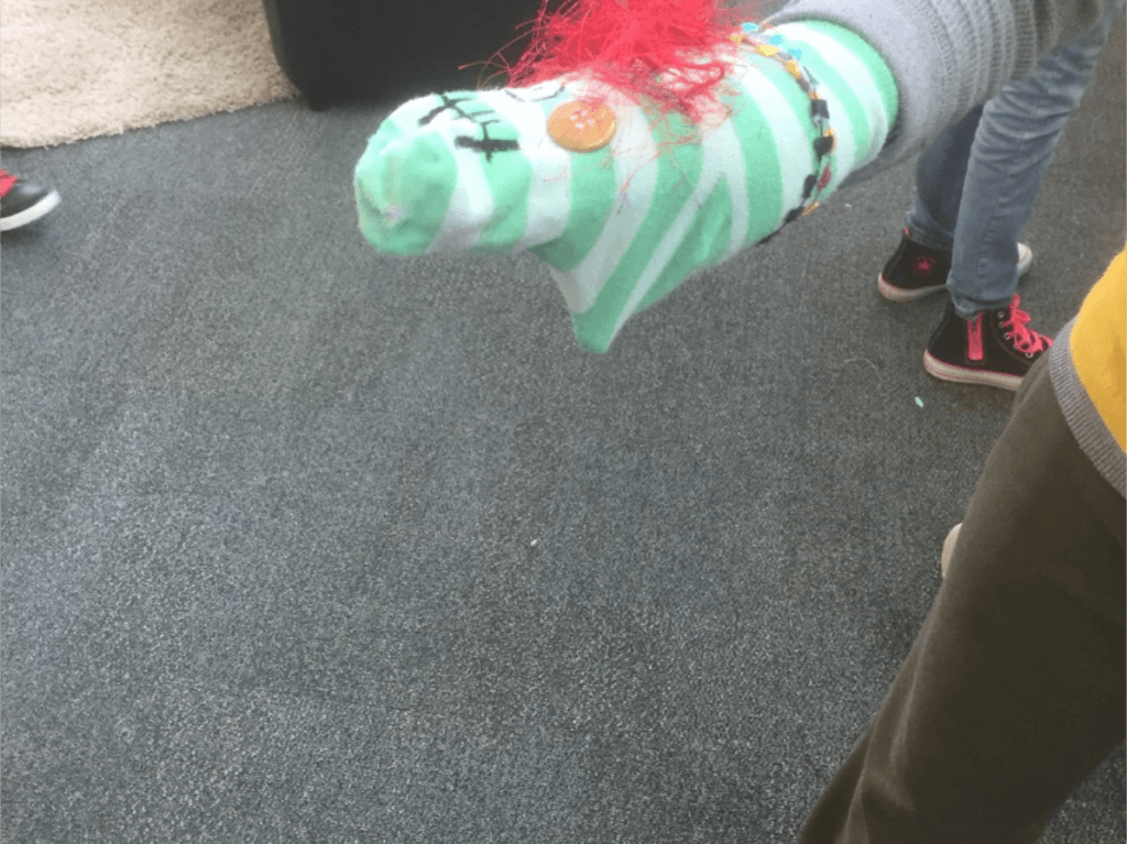 Student shows off their sock puppet project