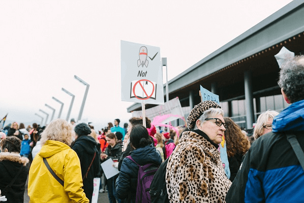 Protesters holding a sign that reads bombs not books