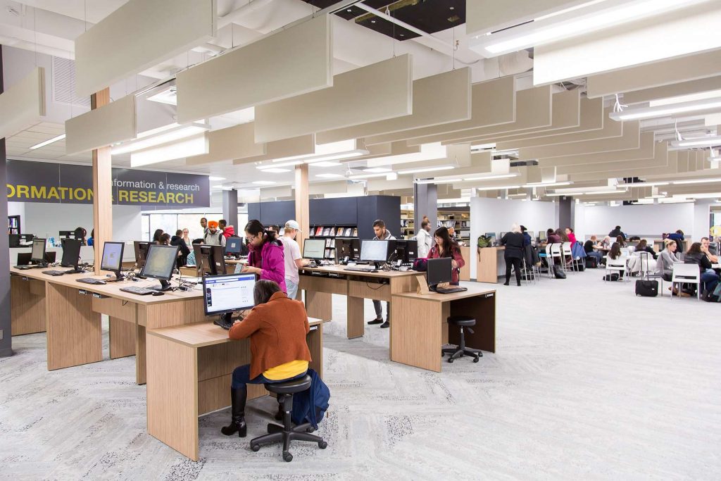 Image of a library interior with computer workstations. Acoustic panels are hanging from the ceiling.